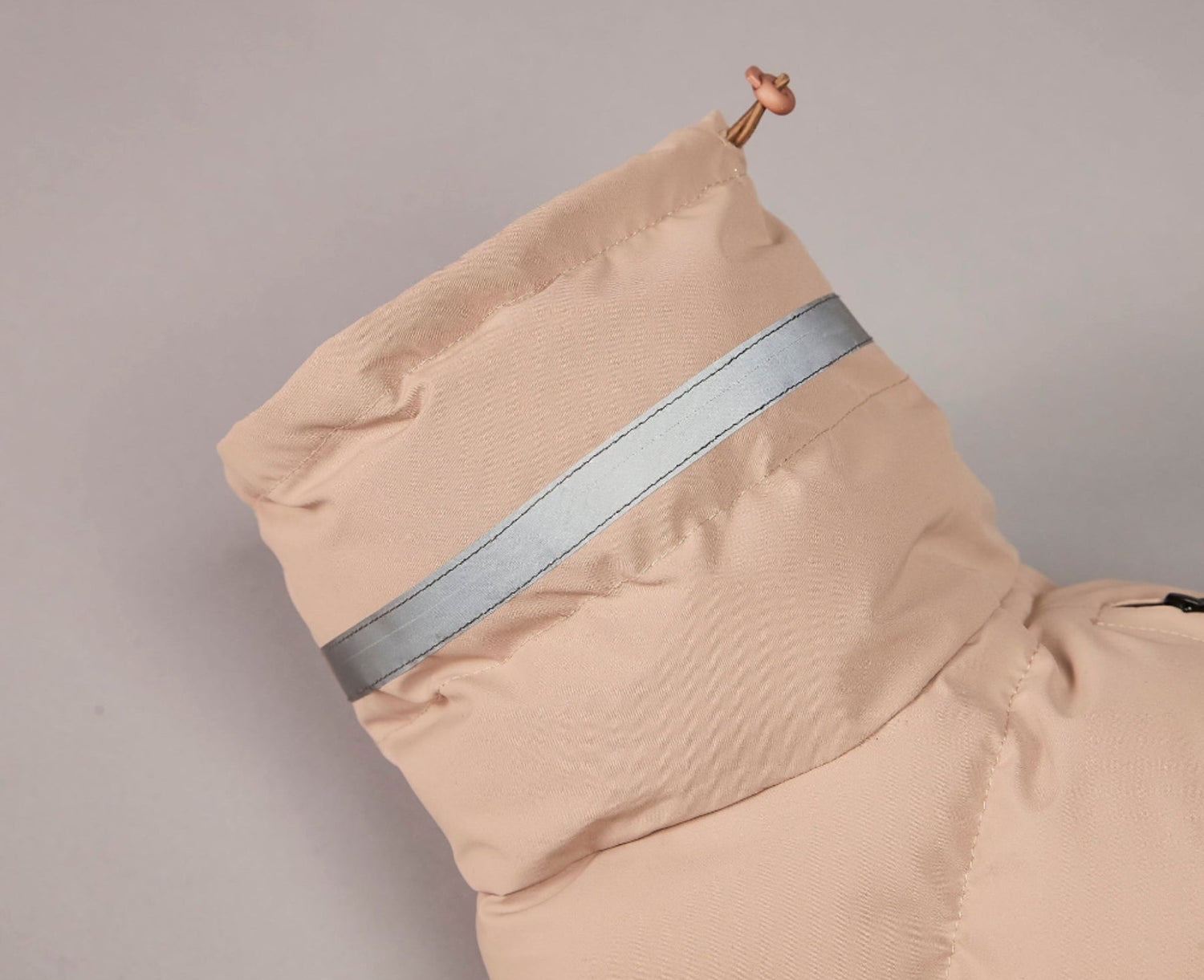 Beige jacket with reflective strip on a gray background